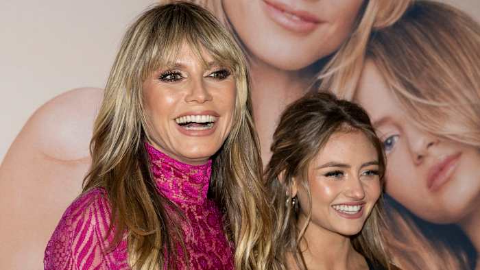 Heidi and Leni Klum smile on the red carpet in front of an enlarged photo from their Intimissimi campaign.